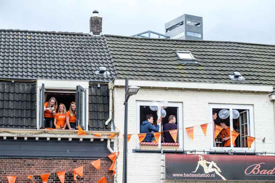 Studenten hangen uit het raam tijdens Koningsdag Tilburg 2017